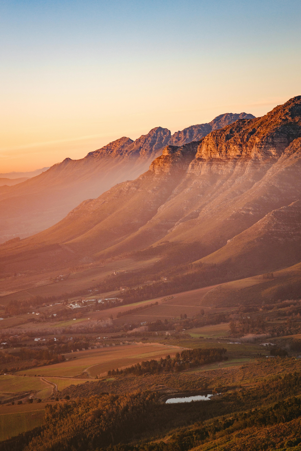 Golden morning light casting soft hues over Cape Town’s iconic mountain range