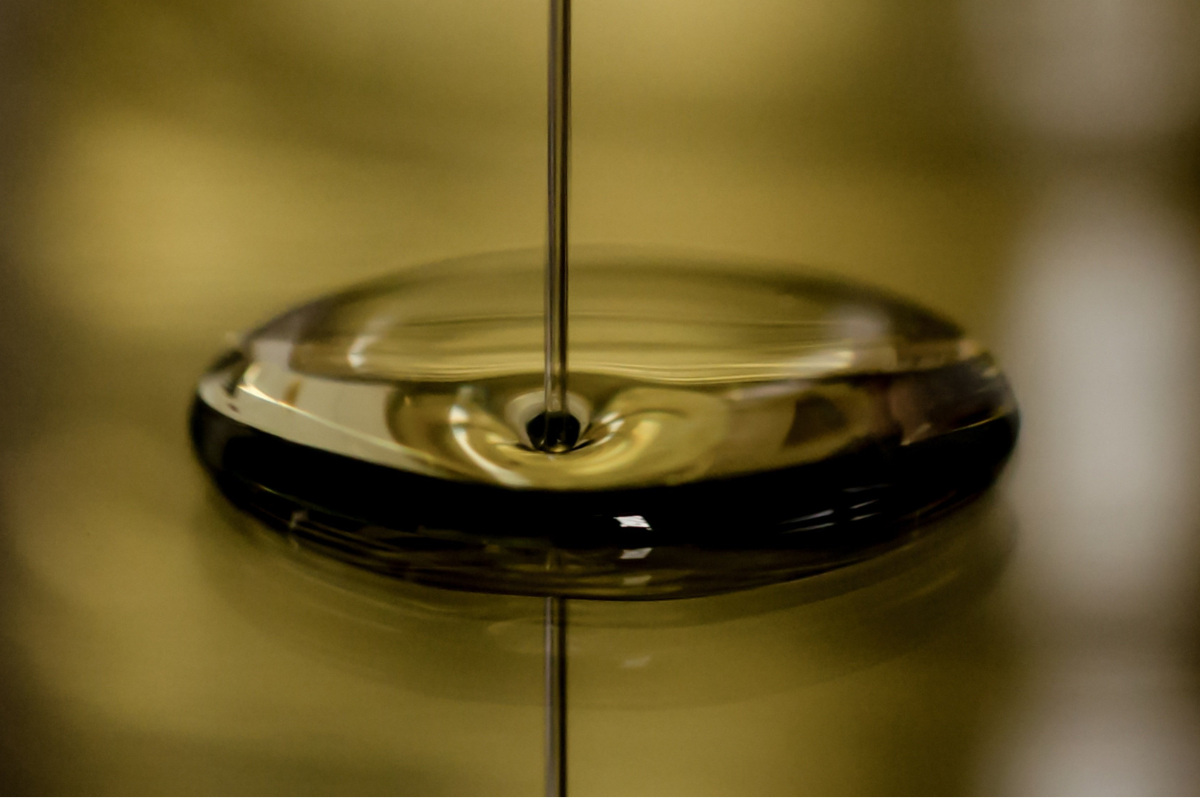 Close-up of olive oil being poured in a smooth stream.
