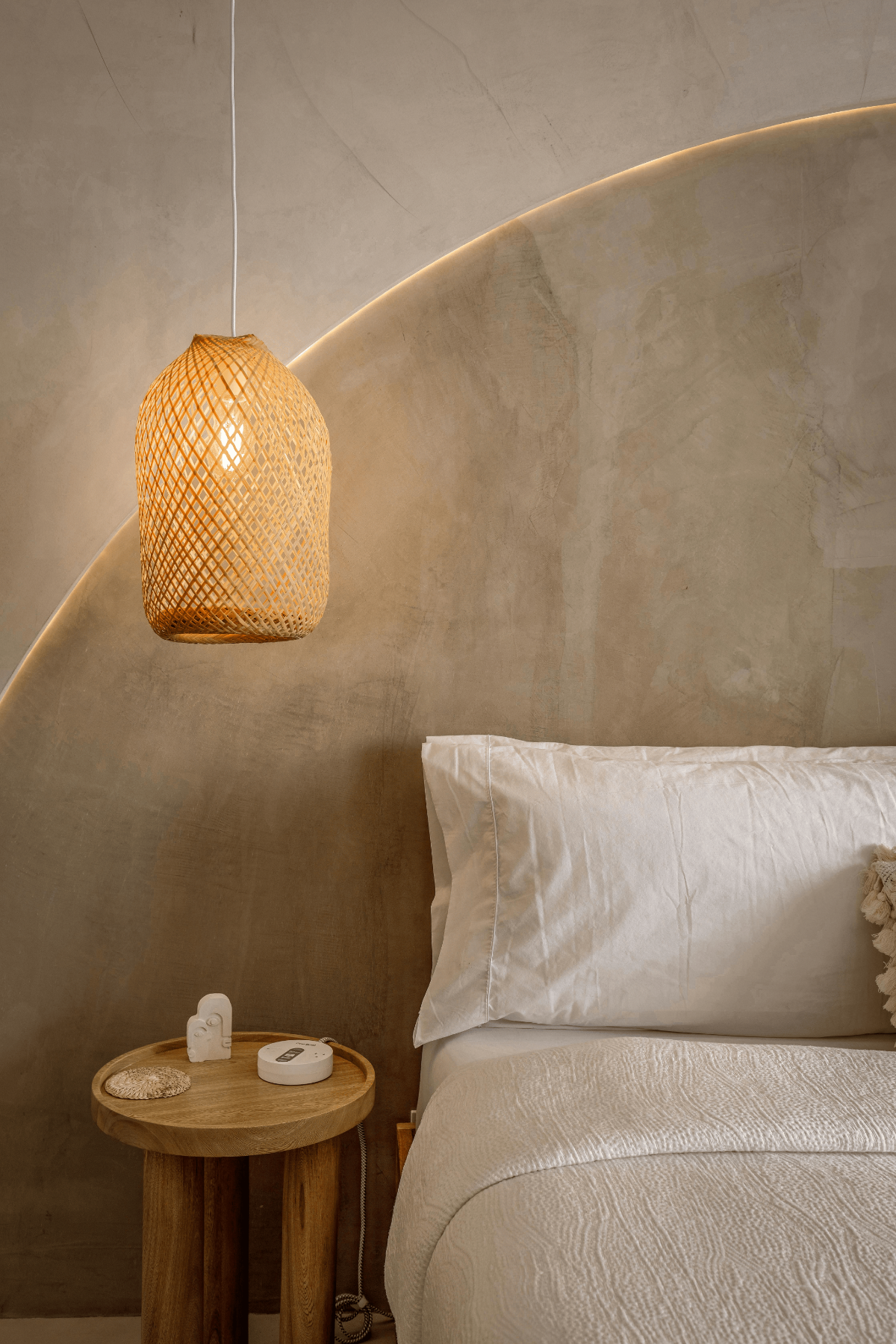 Earth-toned bedroom with natural linen bedding and woven pendant light.