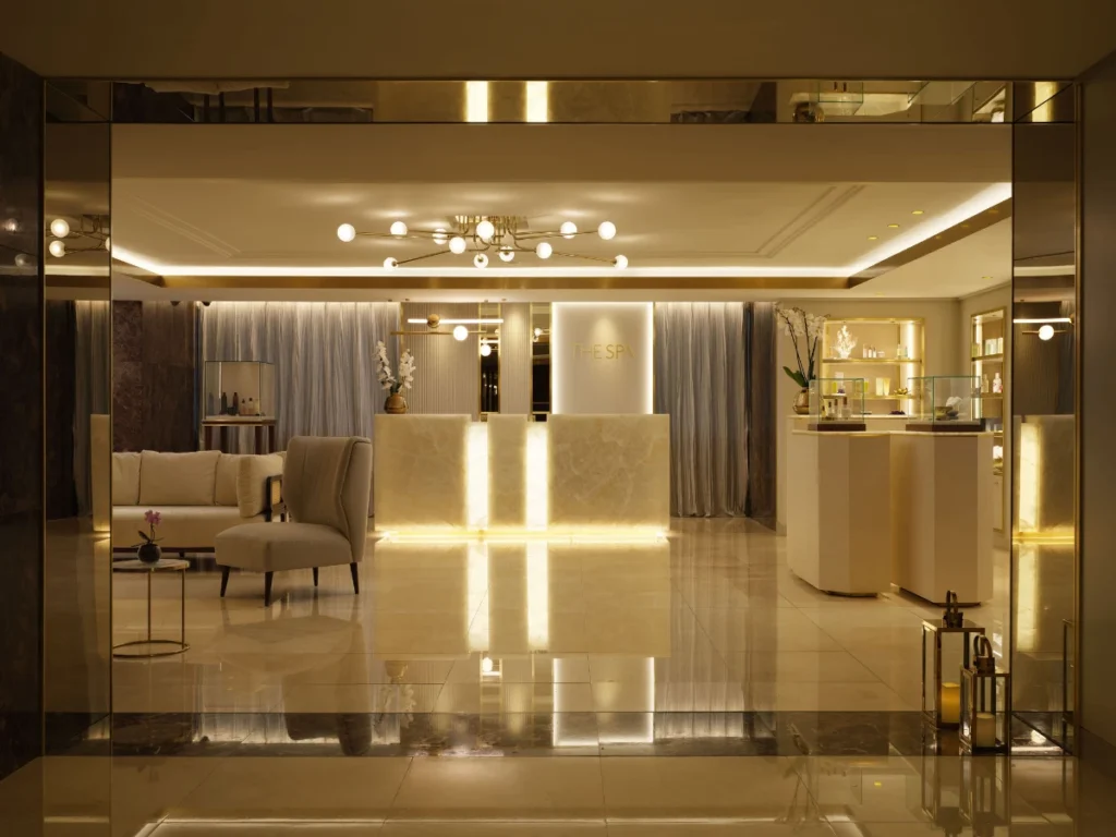 Corinthia Lisbon spa reception with warm lighting, marble desk, and luxury lounge seating