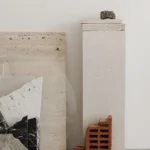 Minimalist display of travertine, marble, brick and lava stone samples for modern interior design inspiration.
