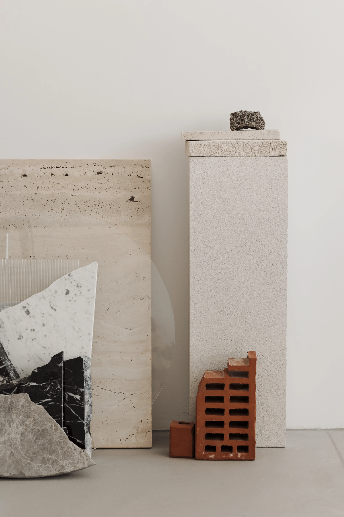 Minimalist display of travertine, marble, brick and lava stone samples for modern interior design inspiration.