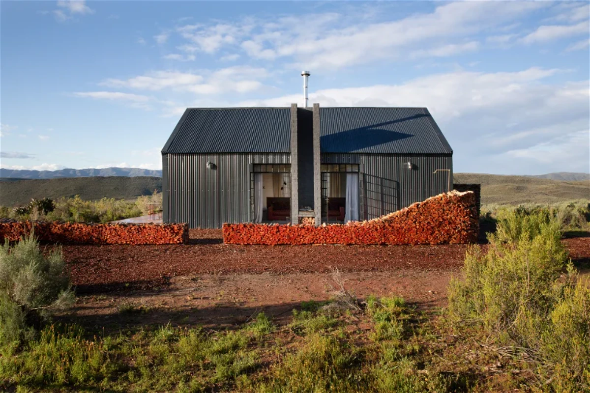 Wooden deck at Poortjies eco cabin overlooking mountain landscape with outdoor seating and natural surroundings.