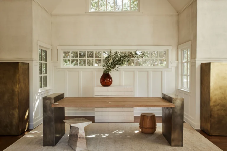 An oak table on patinated metal plinths in a Santa Barbara wine tasting room by Corinne Mathern Studio.