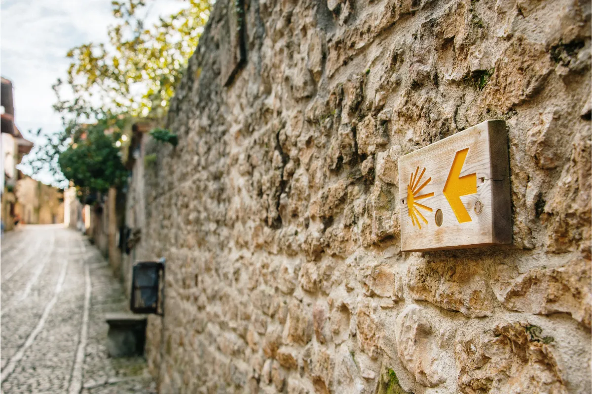 Wooden Camino de Santiago scallop-shell arrow sign.