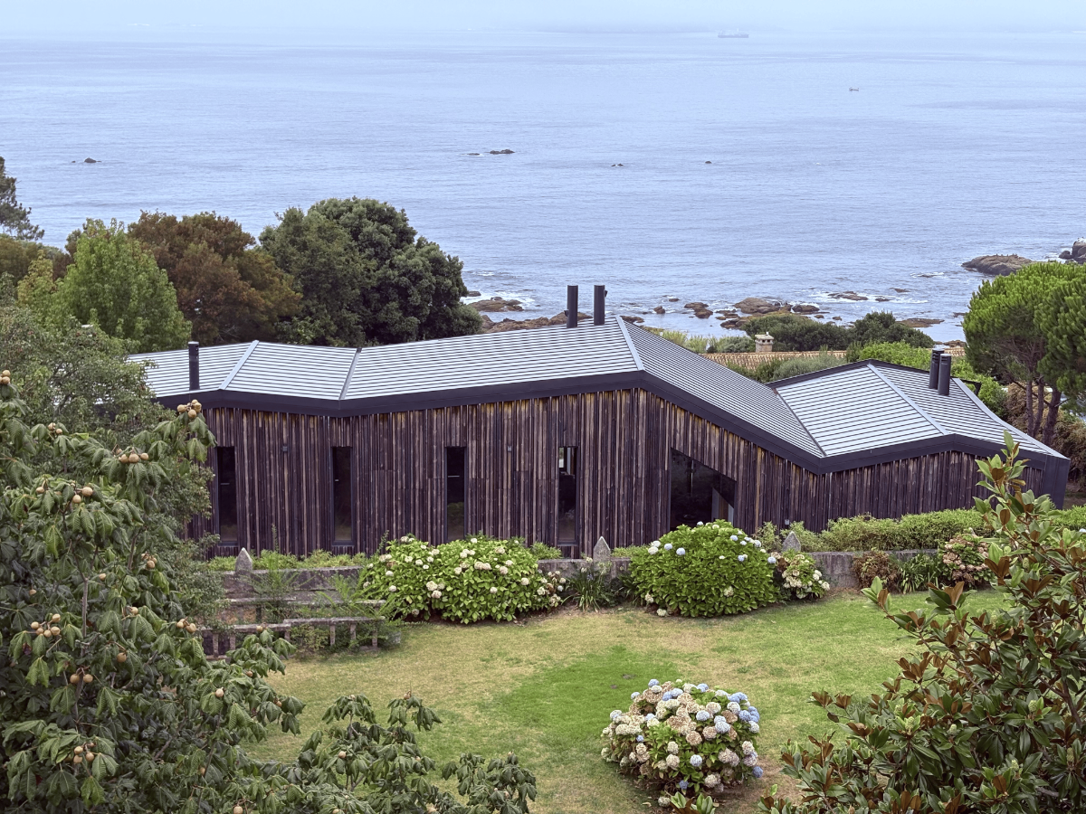Contemporary dark-timber house overlooking the Ría de Vigo coastline.