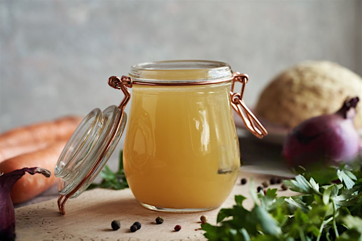 Clip-top glass jar of golden homemade bone broth.