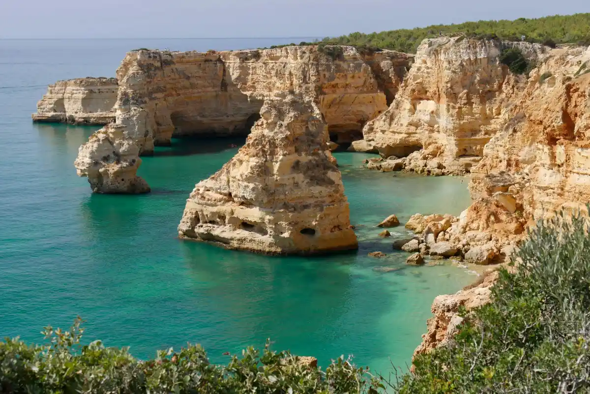 Dramatic limestone sea stacks rise from clear teal water along the Seven Hanging Valleys Trail.