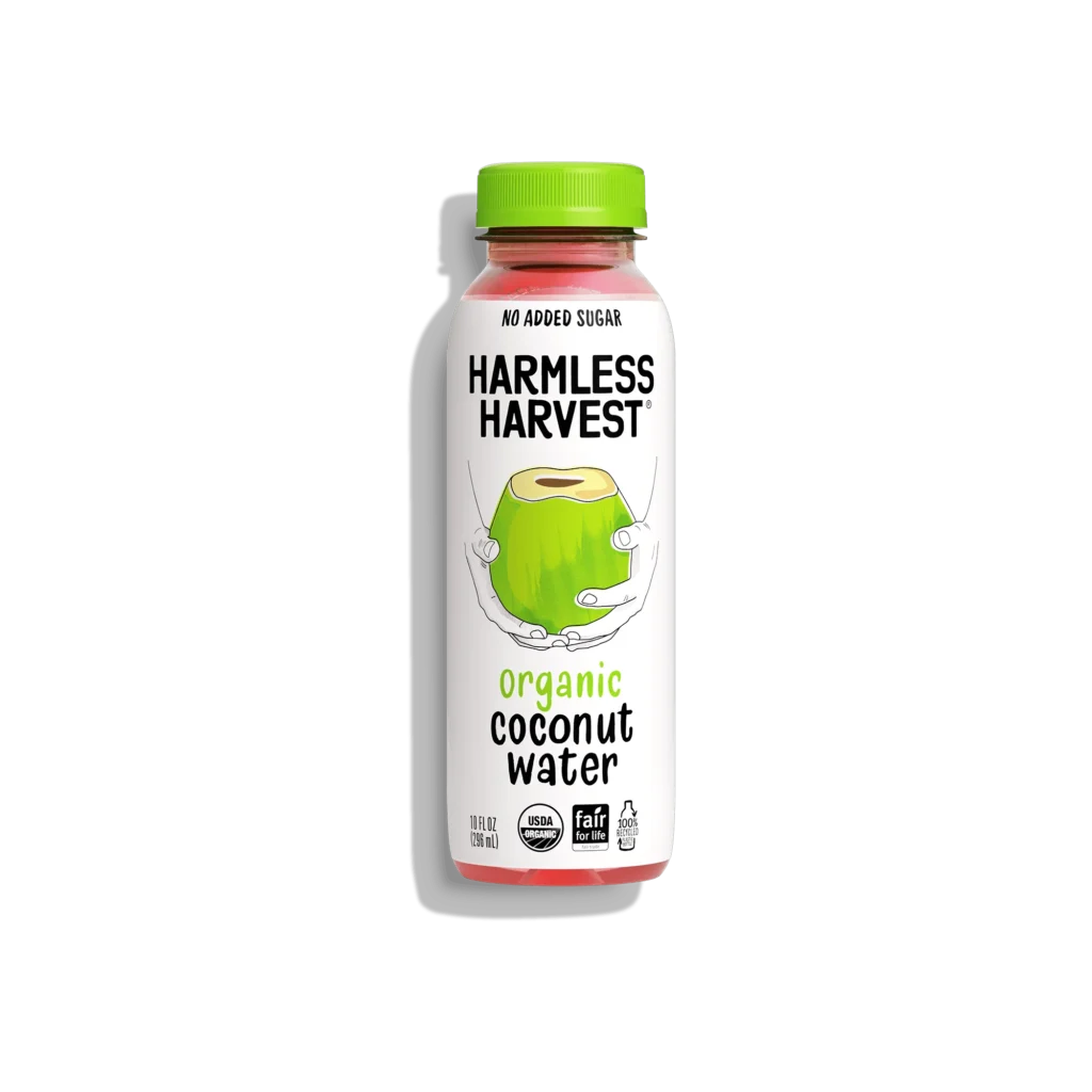 Harmless Harvest organic coconut water bottle with green cap and hand-held coconut illustration on clean white label.