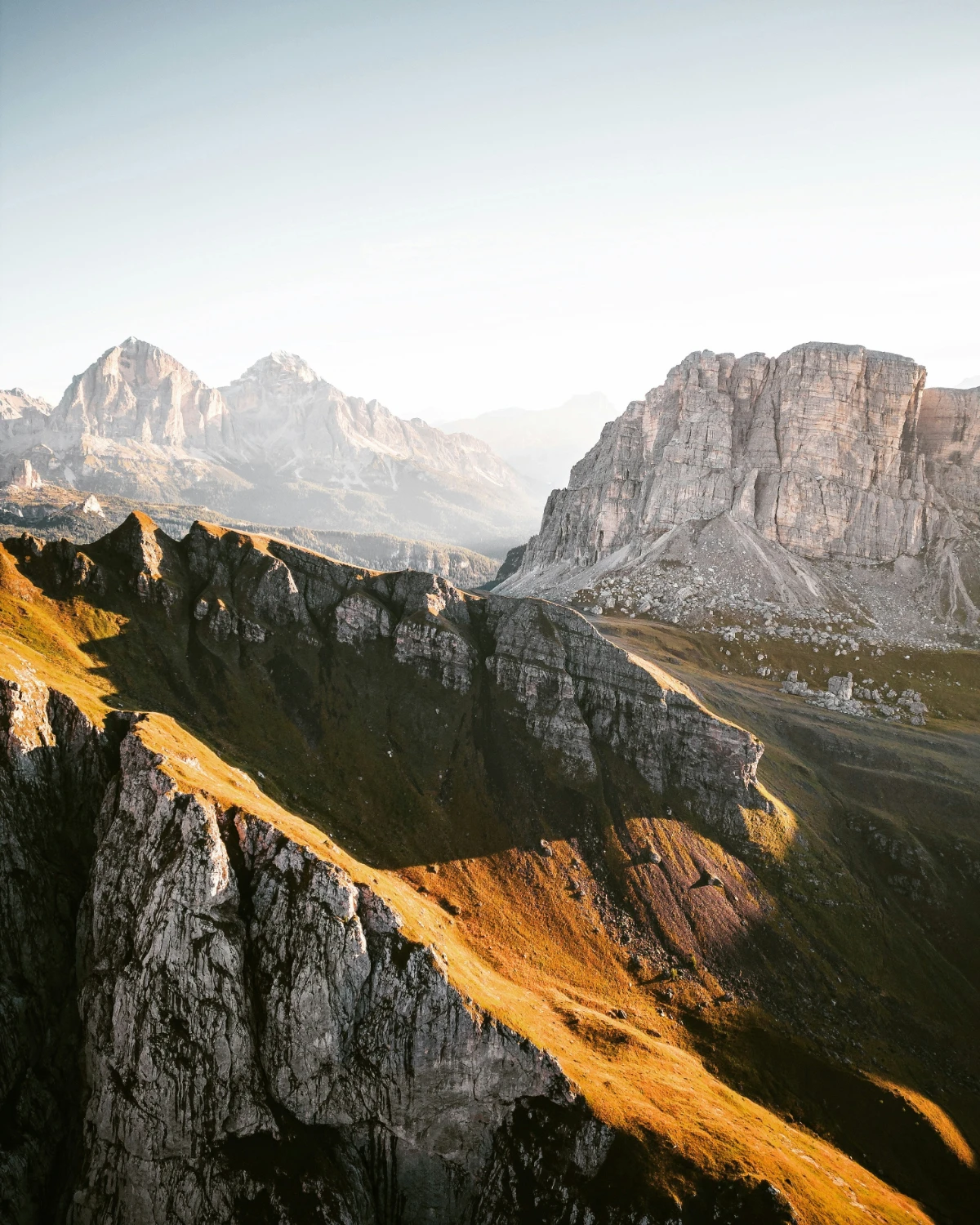 Expansive Dolomites ridgeline with layered mountains and soft golden alpine light.