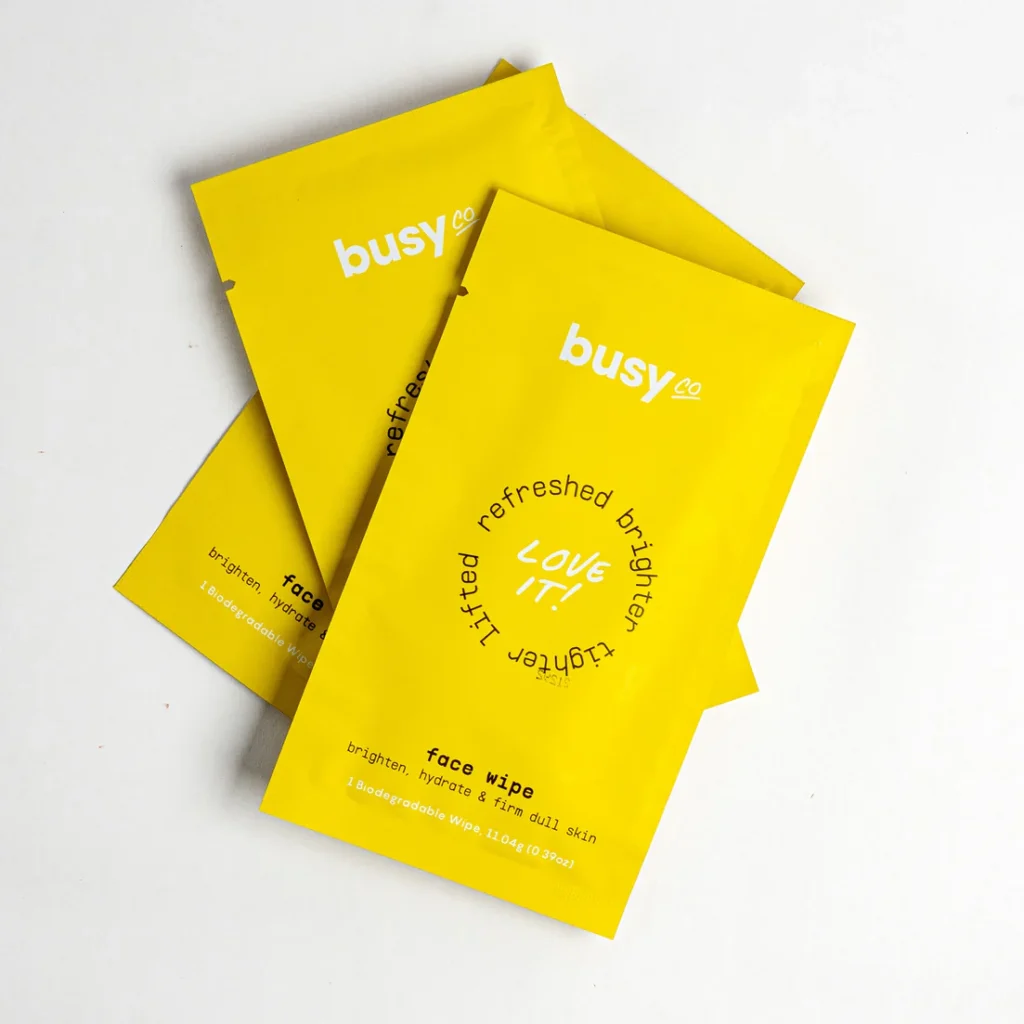 Busy Co biodegradable face wipes in bright yellow packaging on white background