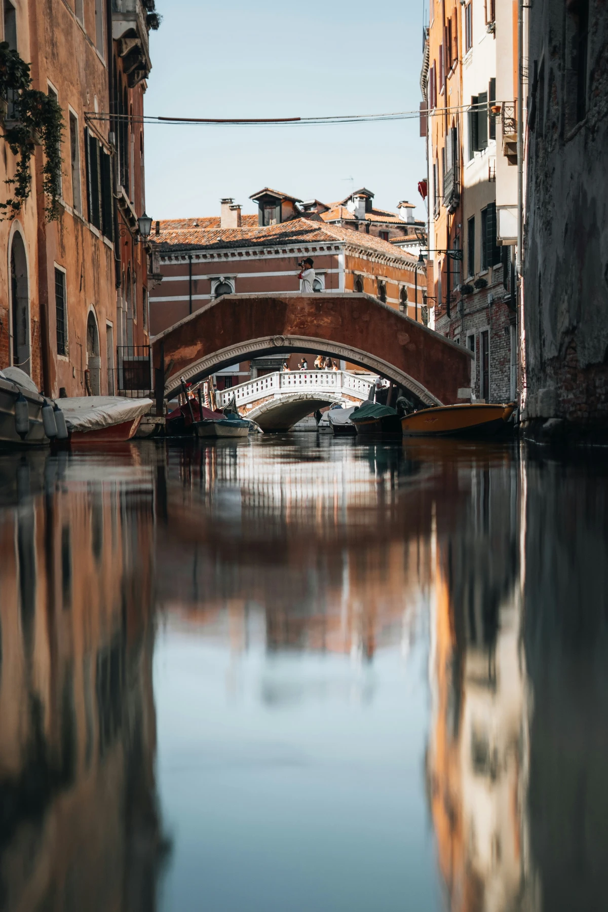 Narrow canal in Venice’s Dorsoduro district with boats, balconies, and warm evening light