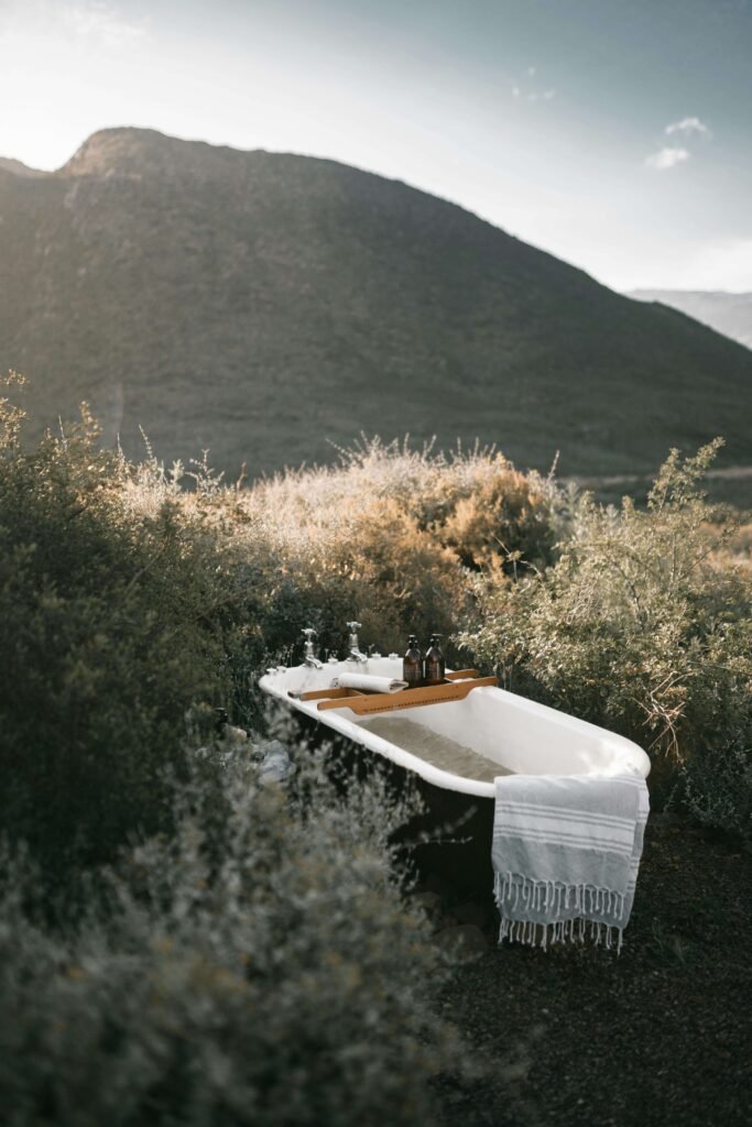 Vintage outdoor bathtub surrounded by nature in a tranquil open-air bathing setting