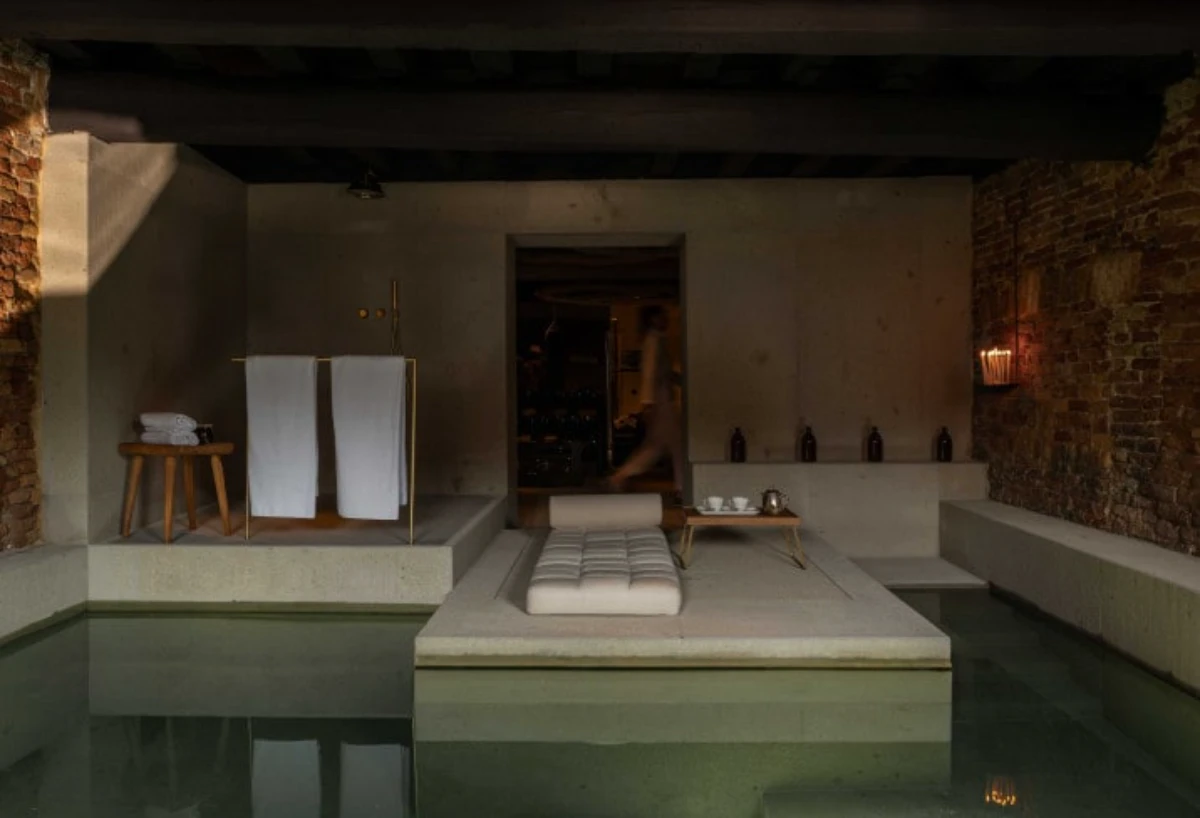 Moody indoor spa pool at The Venice Venice hotel with exposed brick and candlelit details