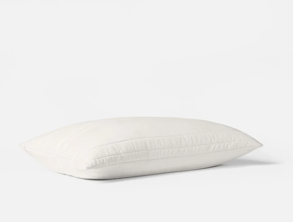 The Coyuchi washable wool pillow rests at an angle, showing its quilted channel stitching.