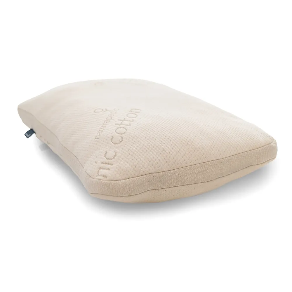 A Naturepedic organic cotton pillow displays its embossed branding along the gusseted edge.