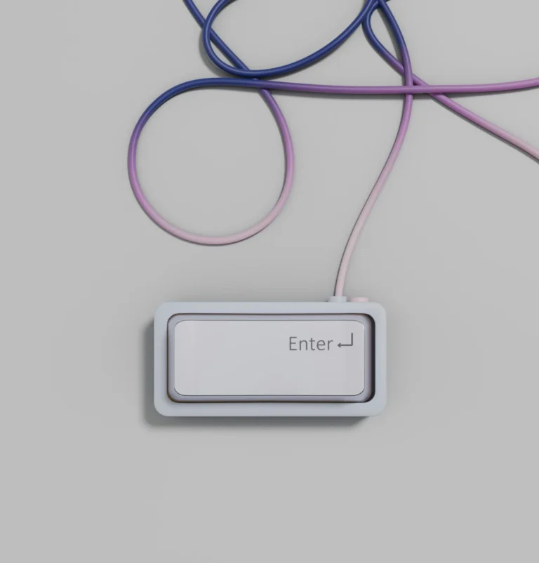 Minimalist Enter key button connected to a curved cable over a plain grey surface.