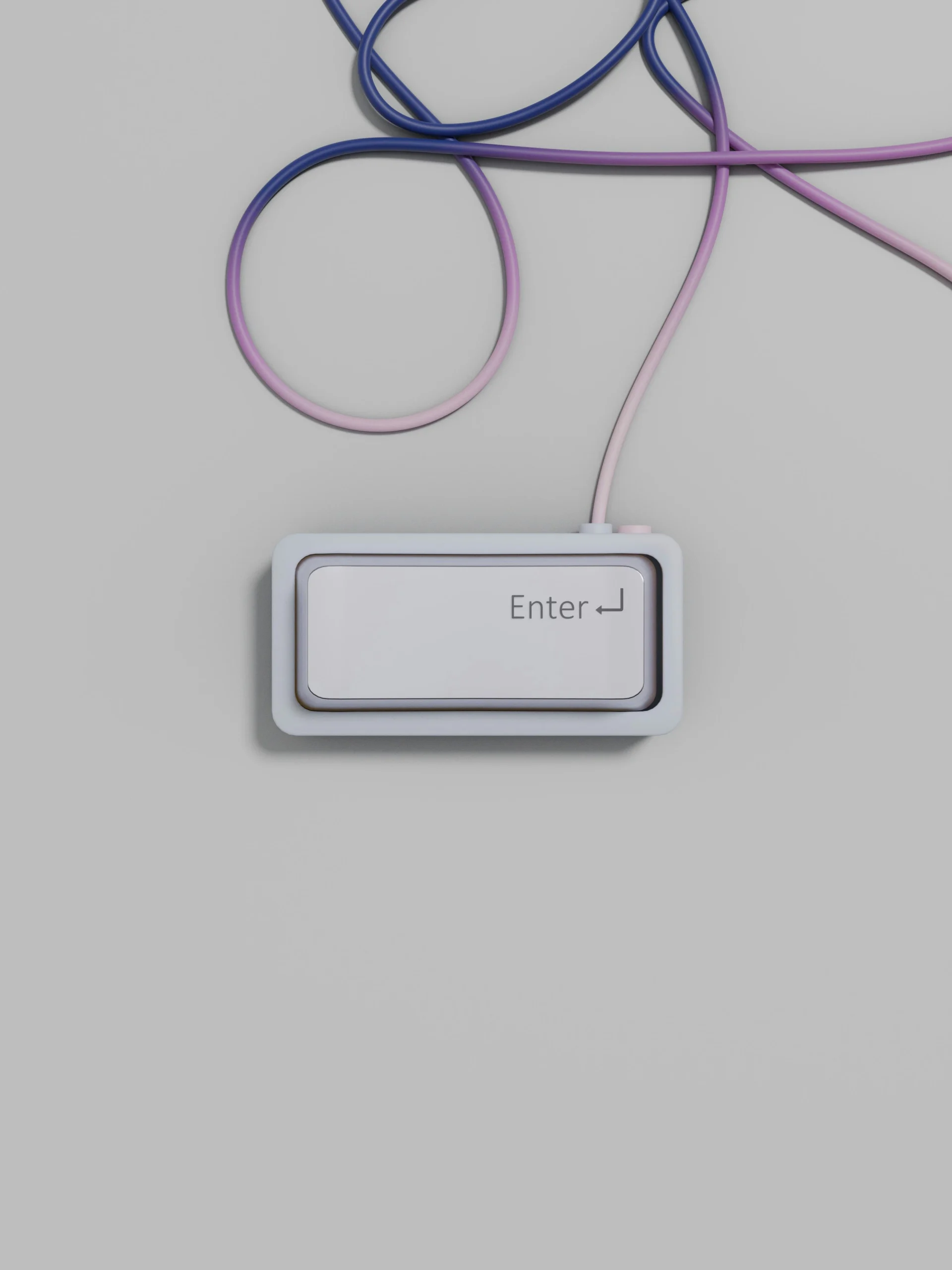 Minimalist Enter key button connected to a curved cable over a plain grey surface.